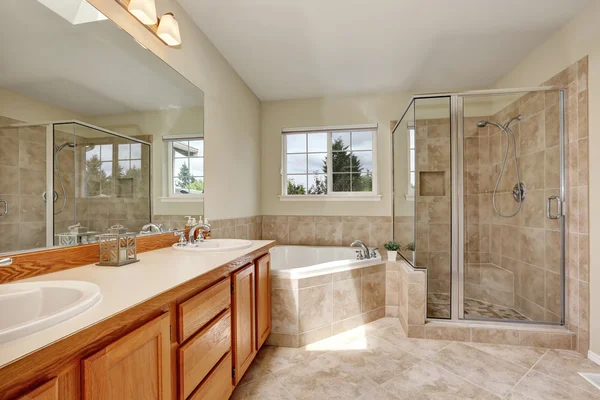 Casa de banho principal com banheira de canto e piso de azulejo — Fotografia de Stock
