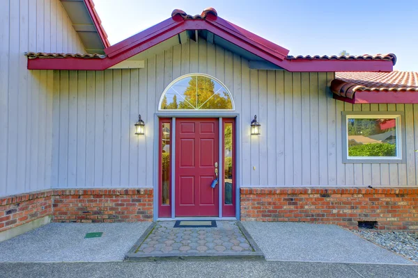 Vista da porta da frente vermelha e duas lâmpadas de decoração — Fotografia de Stock