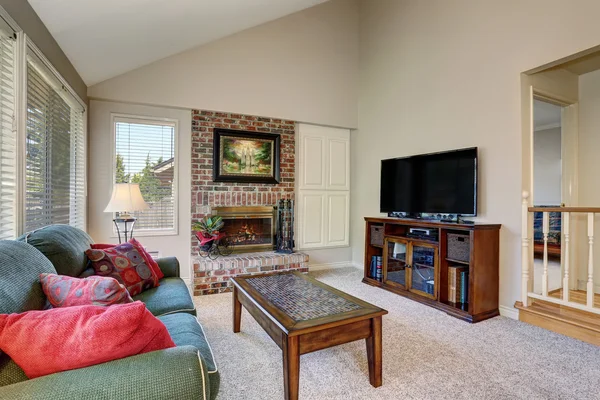 Traditional living room interior with green sofa and brick fireplace. — Stock Photo, Image