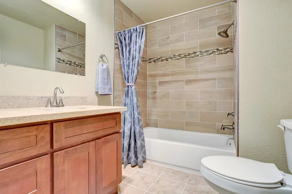 Interior do banheiro com armário de vaidade e cortina de chuveiro azul . — Fotografia de Stock