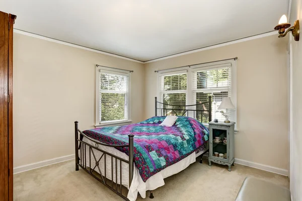 Intérieur de la chambre avec literie colorée et sol tapis . — Photo