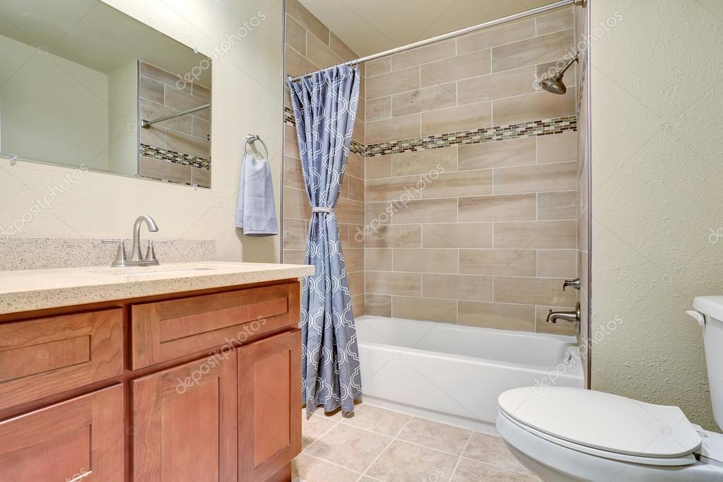 Interior de cuarto de baño con cortina de ducha azul y gabinete de ... Interior de cuarto de baño con cortina de ducha azul y gabinete de ...