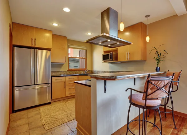 Interior pequeno da sala de cozinha com armários castanhos claros e piso de azulejos . — Fotografia de Stock