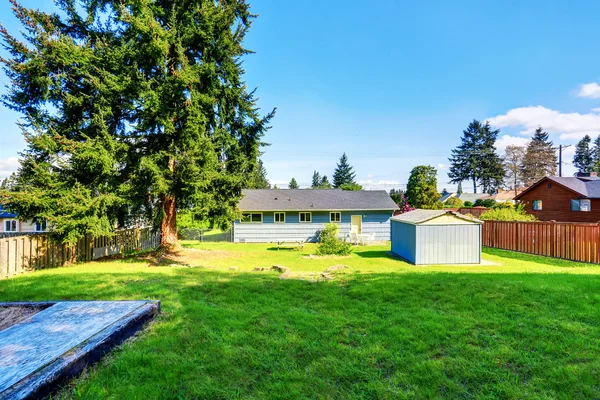 Spacious back yard of blue house with small shed — Stock Photo, Image