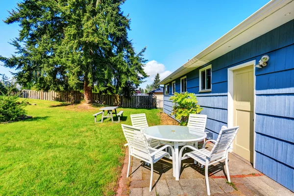 Blick auf Terrassentisch im Hinterhof des blauen Hauses. — Stockfoto