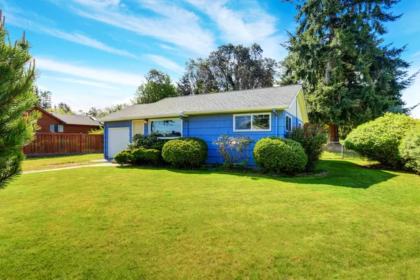 Pequeña casa azul lindo con césped bien cuidado y setos recortados . —  Fotos de Stock