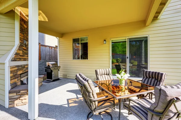 Gemütliche überdachte Terrasse mit Steinverkleidung Kamin und Grill. — Stockfoto