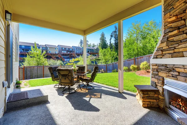 Cozy covered patio with stone trim fireplace. — Stock Photo, Image