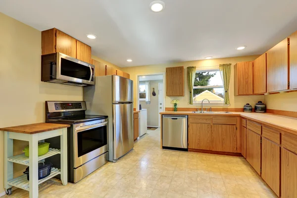 Classic kitchen room interior with wooden cabinets, tile floor and window with green curtains — Stock Photo, Image