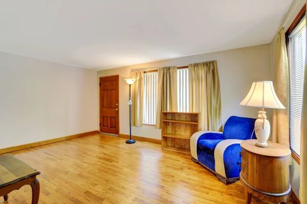 Acogedora sala de estar con suelo de madera y sillón azul en la esquina . — Foto de Stock