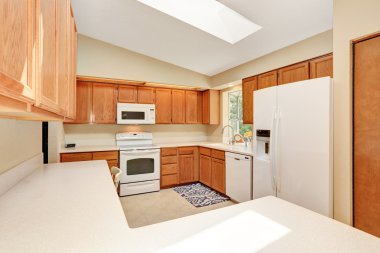 Ahşap dolaplar ve beyaz tezgah üstü ile beyaz tonları Kicthen.