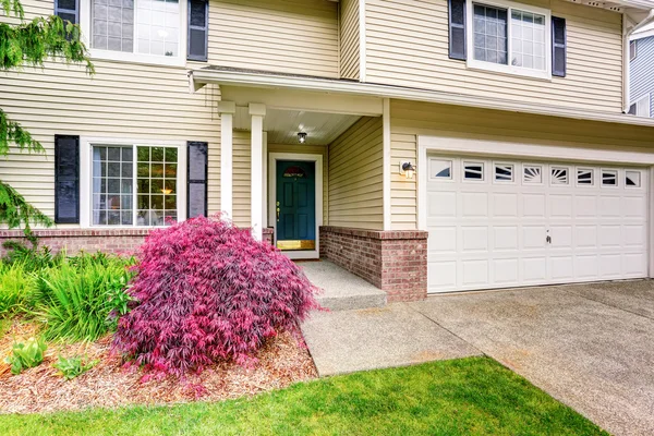 Amerikaans huis met Siding trim en goed onderhouden tuin rond. — Stockfoto