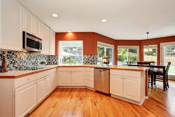 Interior de la cocina blanca con encimera de baldosas y suelo de madera . — Foto de Stock