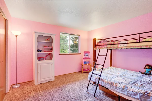 Różowa sypialnia dla dzieci z białymi meblami i podłogą dywanową. — Zdjęcie stockowe