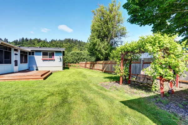 Fenced backyard and hanging swing with nice landscape desing. — Stock Photo, Image