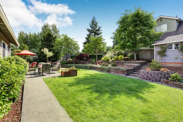 Ухоженный сад на заднем дворе с бетонным полом — стоковое фото