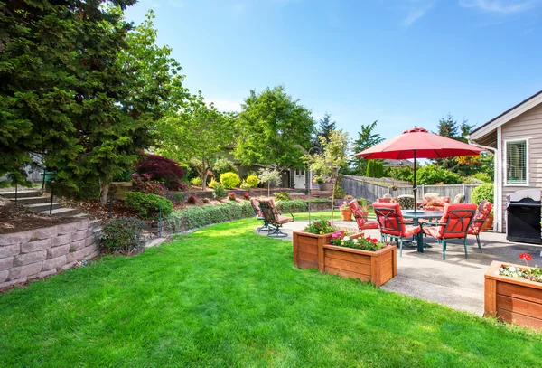 Jardín bien cuidado en el patio trasero con patio de suelo de hormigón — Foto de Stock