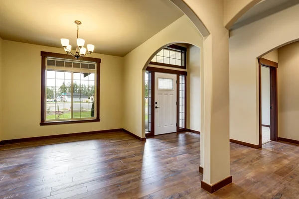 Interior do corredor com colunas, piso de madeira e porta de entrada branca — Fotografia de Stock