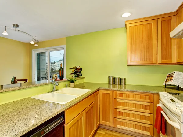 Dapur sederhana dengan lemari kayu dan meja granit atas . — Stok Foto