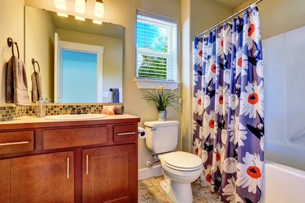 Bonito baño interior con gabinete moderno y cortina de ducha floral . — Foto de Stock