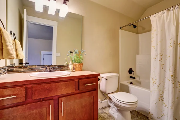 Bathroom with white bath tub, tile floor and vanity cabinet — Stock Photo, Image