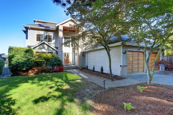 Casa de lujo exterior con garaje doble y jardín bien cuidado alrededor . — Foto de Stock