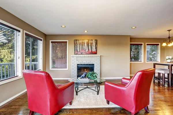 Acogedor salón interior con chimenea y dos sillones rojos —  Fotos de Stock