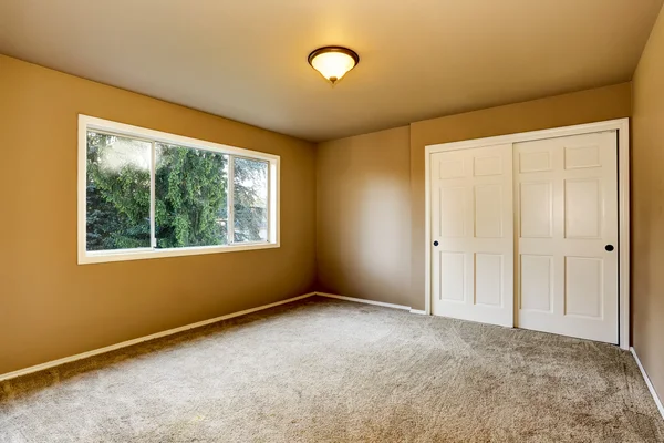 Intérieur de la chambre vide avec des murs beige et une armoire . — Photo