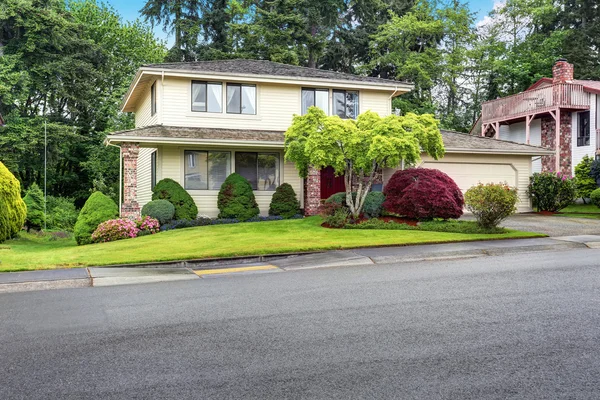 Luxe Amerikaanse twee verdiepingen tellende huis met gevelbekleding en bakstenen trim. — Stockfoto