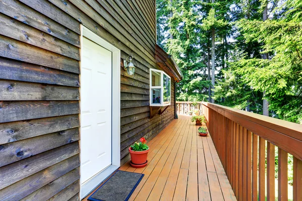 Balcón exterior de la casa con adornos de madera y macetas de flores . — Foto de Stock