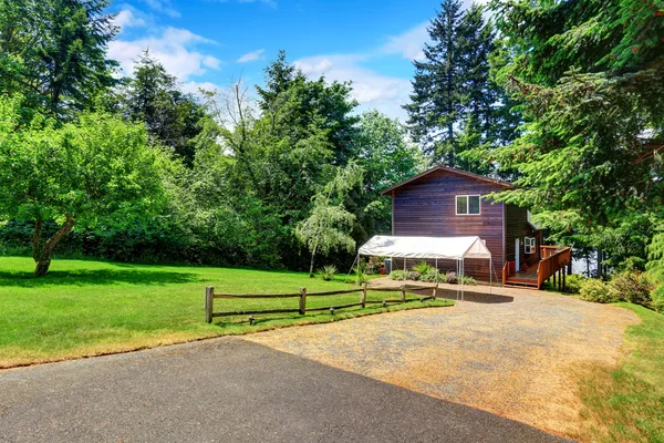 Maison de jardin avec garniture en bois et chapiteau, pelouse bien entretenue — Photo