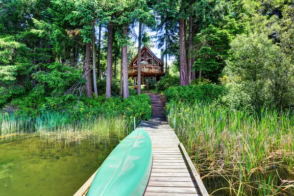 Exteriér s dřevěnými polštářty a velkým balkonem. Stromy kolem. — Stock fotografie