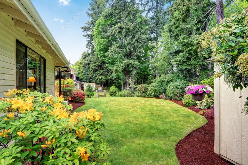 Well kept garden at backyard with trees, bushes and flowers