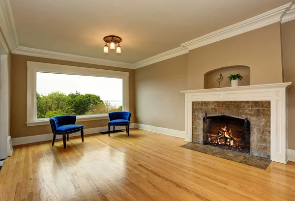 暖炉と青いアームチェアが備まる空のリビングルームのインテリア. — ストック写真