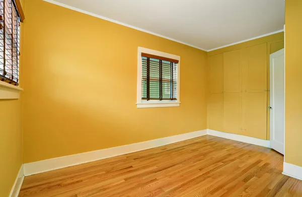 Interior do quarto vazio em tons amarelos e piso em madeira . — Fotografia de Stock