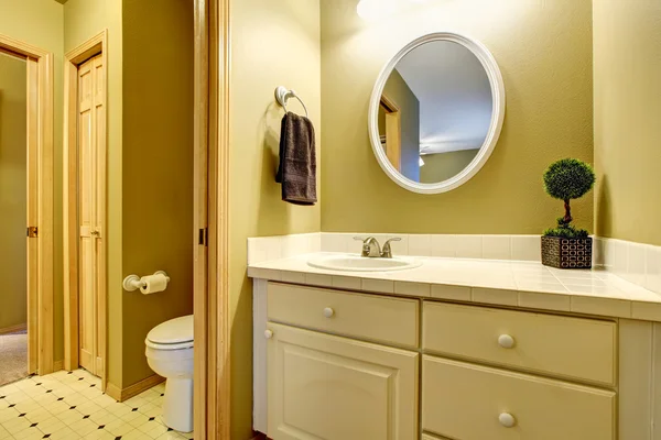 Interiér koupelny ve žlutém tónu s marnivými skříňmi — Stock fotografie