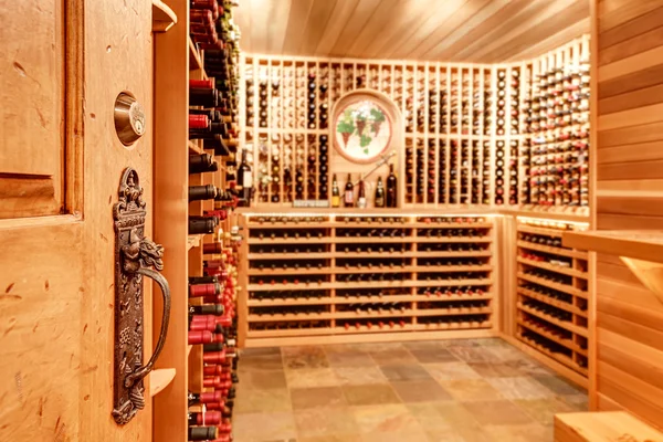 Jasna piwnica z winami z drewnianymi magazywami z butelkami. — Zdjęcie stockowe