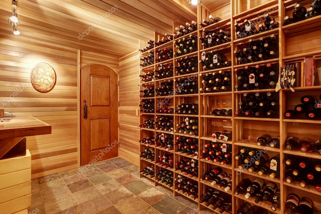 Bright home wine cellar with wooden storage units with bottles. — Stock