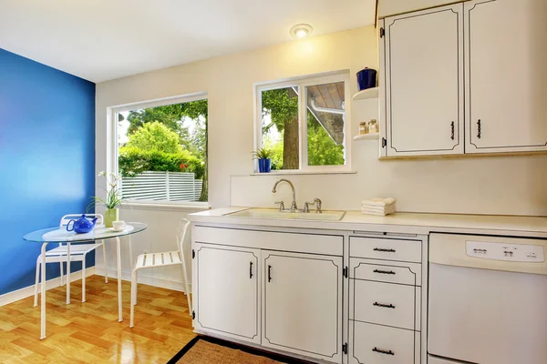 Kuchyňský pokoj s bílými skříňkami, modrými stěnami a skleněnými — Stock fotografie