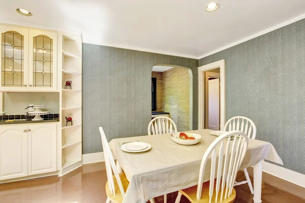 Dining area with table set in white tones and tile floor — Stock Photo, Image