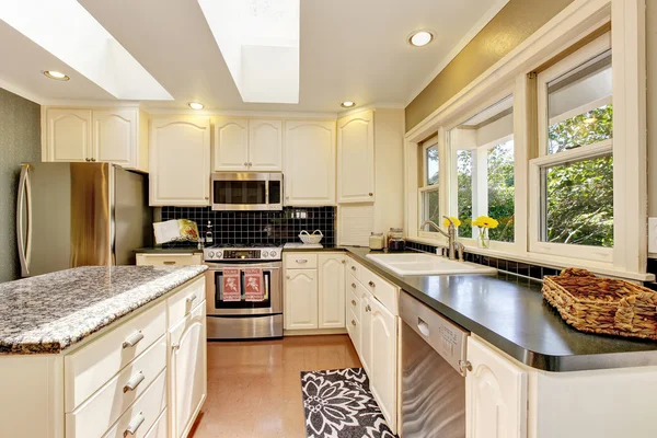 Cozinha branca com tampos de granito. Ilha da cozinha e piso de azulejos . — Fotografia de Stock