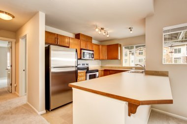 Ahşap dolaplar ve kiremit zemin ile boş mutfak odası iç.