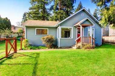 Ahşap güverteli ev. Çiçek yatağı ve çim ile ön bahçesinde