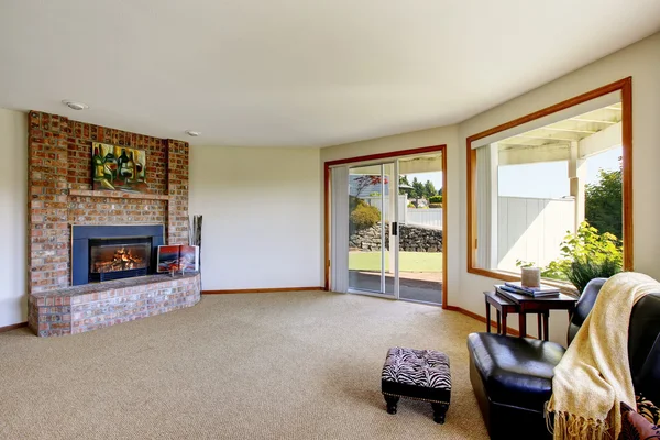 Moderno salón interior con chimenea de ladrillo y sillón de cuero . — Foto de Stock