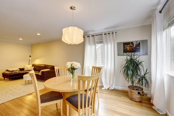 Acogedora zona de comedor con mesa y cortinas en tonos crema . —  Fotos de Stock