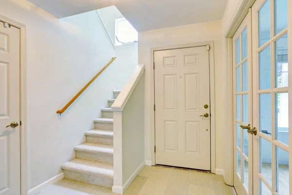 Interior del pasillo en tonos claros con piso de madera y escaleras de alfombra — Foto de Stock