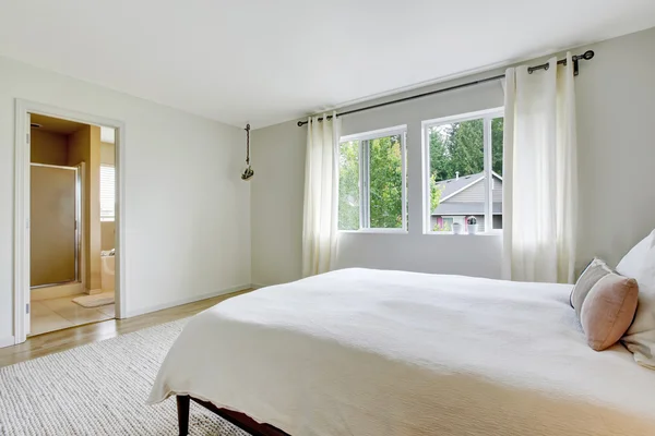 Interior del dormitorio en tonos claros con cama de madera y suelo de madera . —  Fotos de Stock