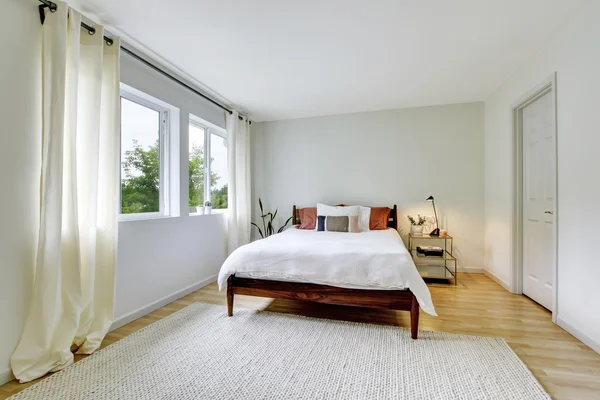 Interior del dormitorio en tonos claros con cama de madera y suelo de madera . —  Fotos de Stock