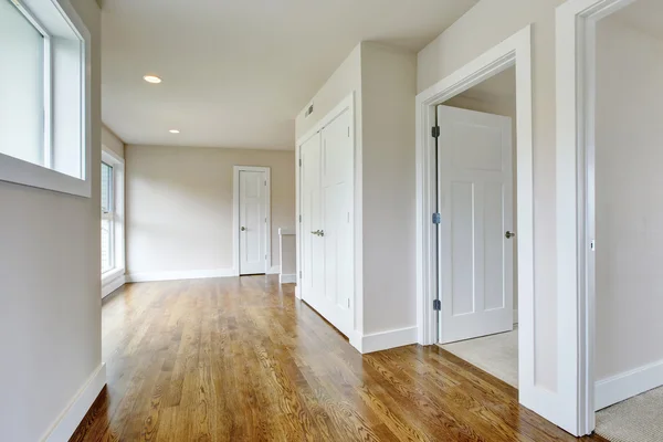 Intérieur du couloir vide dans des tons blancs avec plancher en bois franc — Photo