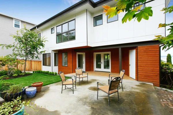 Gemütlicher Betonboden Terrassenbereich mit gedecktem Tisch in der Nähe des modernen Stadthauses. — Stockfoto